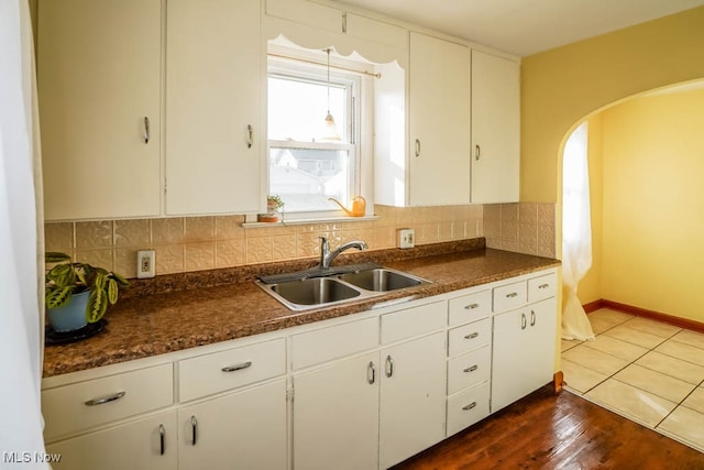 kitchen with white cabinets, backsplash, dark hardwood / wood-style floors, and sink