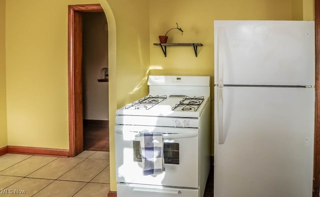 kitchen with light tile patterned flooring and white appliances