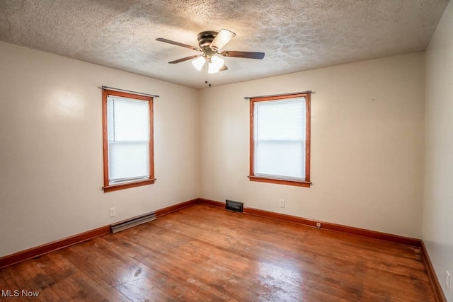 empty room with hardwood / wood-style flooring, ceiling fan, and a textured ceiling