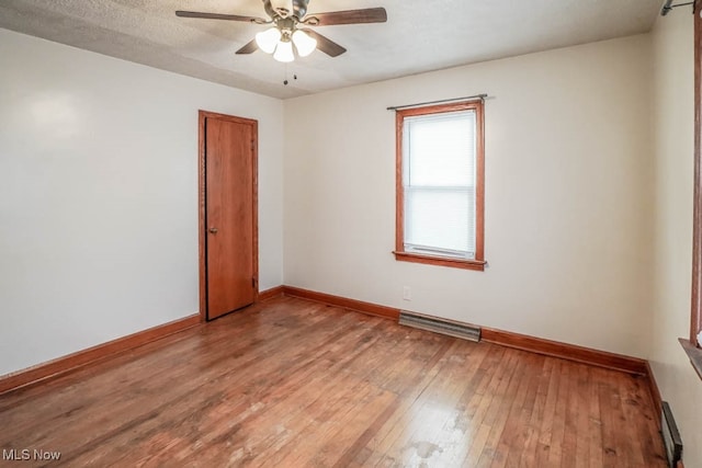 empty room featuring hardwood / wood-style floors, a textured ceiling, and ceiling fan