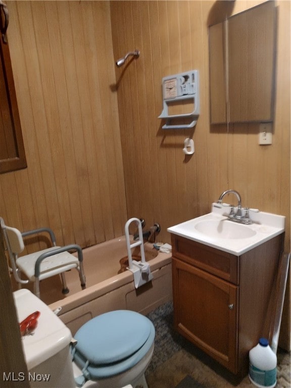 full bathroom with vanity, shower / bath combination, toilet, and wood walls