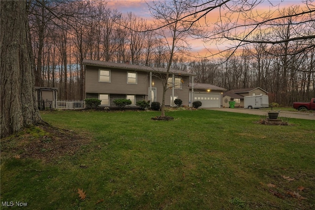 bi-level home featuring a yard and a garage