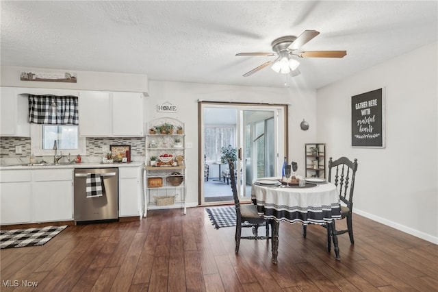 dining space with ceiling fan, sink, dark wood-type flooring, and a textured ceiling