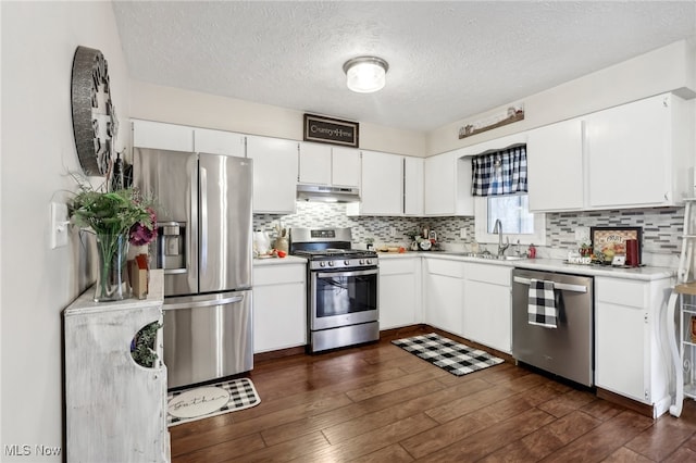 kitchen with dark wood-type flooring, white cabinets, sink, a textured ceiling, and appliances with stainless steel finishes