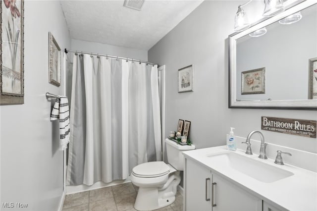 full bathroom with tile patterned floors, a textured ceiling, toilet, shower / bath combo with shower curtain, and vanity