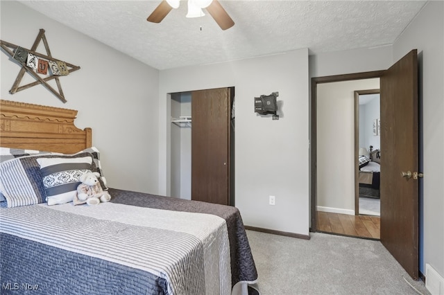 carpeted bedroom featuring a textured ceiling, a closet, and ceiling fan