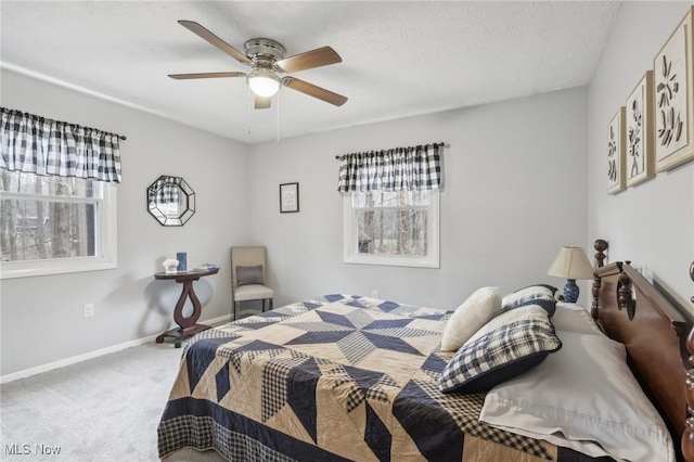 carpeted bedroom featuring ceiling fan, a textured ceiling, and multiple windows