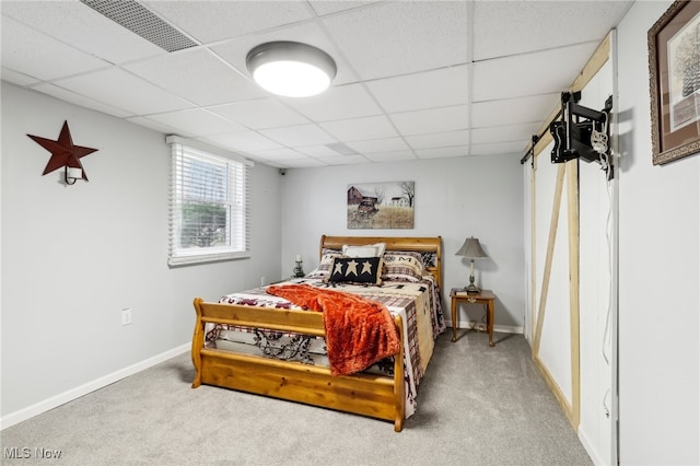 carpeted bedroom featuring a drop ceiling