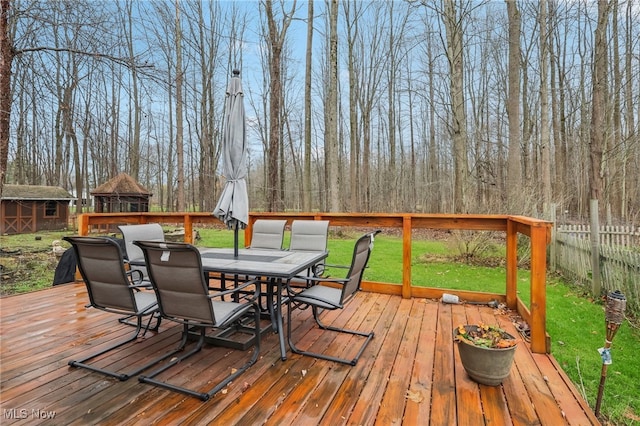 wooden deck featuring an outbuilding and a yard