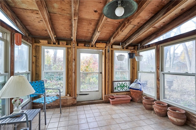 unfurnished sunroom with vaulted ceiling with beams, a wealth of natural light, and wooden ceiling