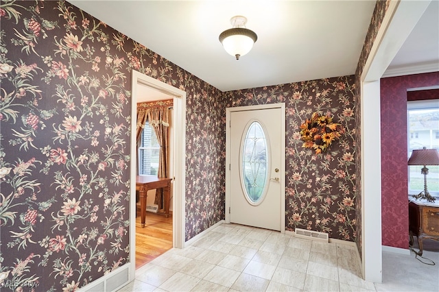 foyer featuring crown molding and light hardwood / wood-style flooring