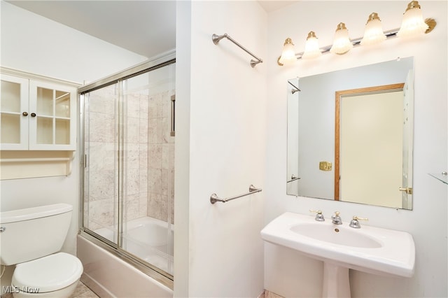 full bathroom featuring combined bath / shower with glass door, toilet, and sink