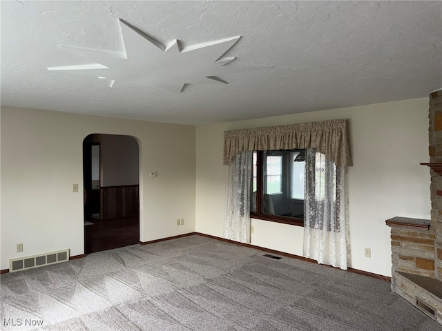 carpeted empty room with a textured ceiling