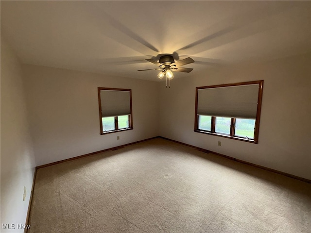 empty room with carpet flooring, ceiling fan, and plenty of natural light