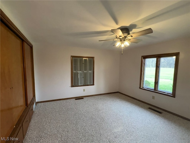 unfurnished bedroom featuring light colored carpet and ceiling fan