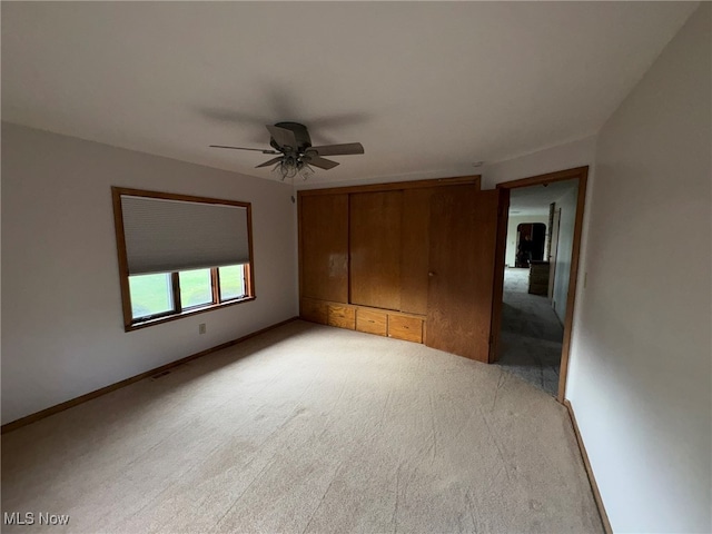 unfurnished bedroom featuring light carpet and ceiling fan