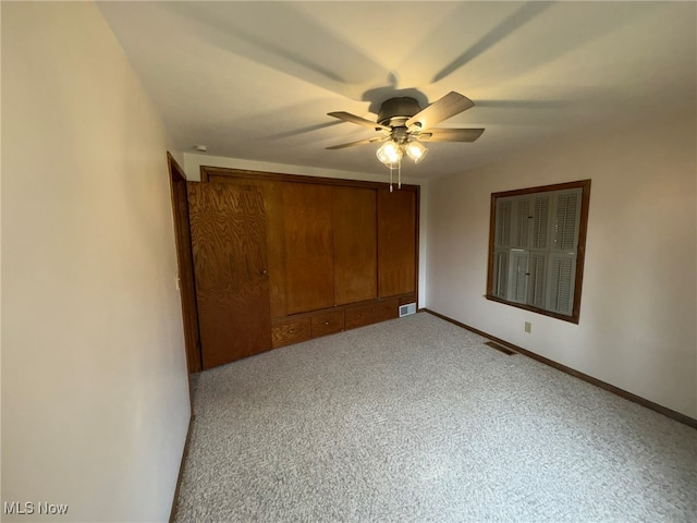 unfurnished bedroom featuring ceiling fan, a closet, and light colored carpet