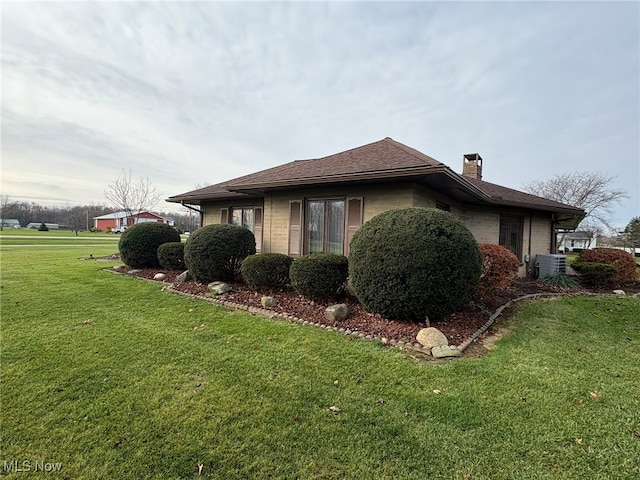 view of side of home featuring a lawn and cooling unit