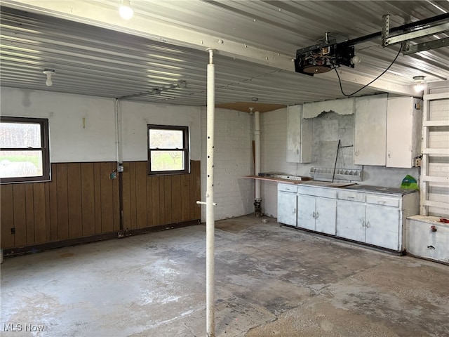 garage featuring wood walls and a garage door opener