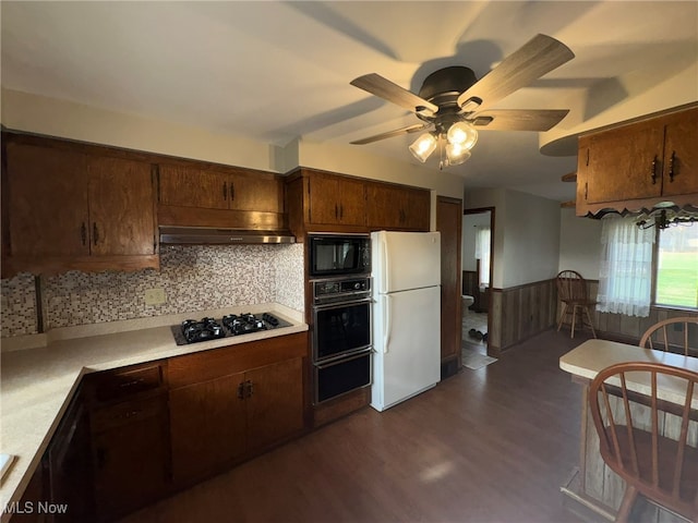 kitchen featuring exhaust hood, black appliances, dark hardwood / wood-style floors, ceiling fan, and tasteful backsplash