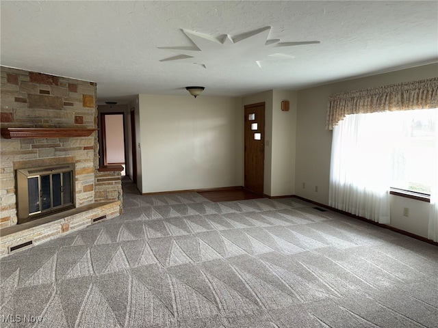 unfurnished living room featuring carpet, a fireplace, and a textured ceiling