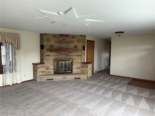 unfurnished living room with carpet flooring, a fireplace, and a textured ceiling