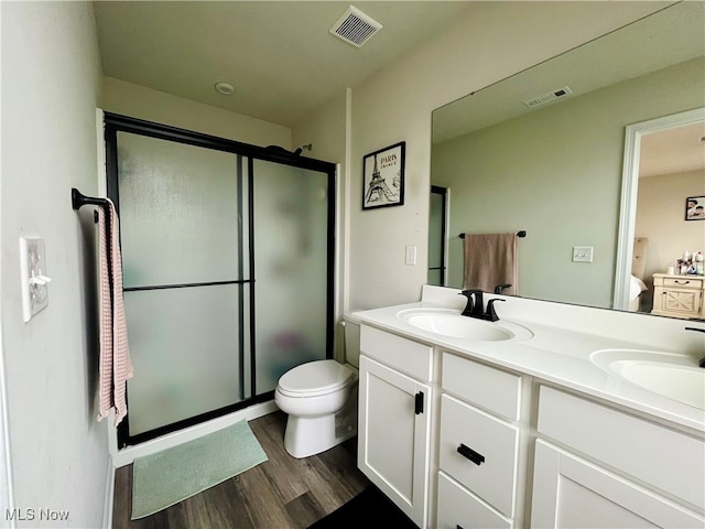 bathroom featuring hardwood / wood-style floors, vanity, toilet, and an enclosed shower