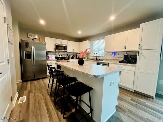 kitchen with white cabinets, a center island, and stainless steel appliances