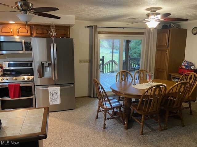 dining space with ceiling fan and a textured ceiling