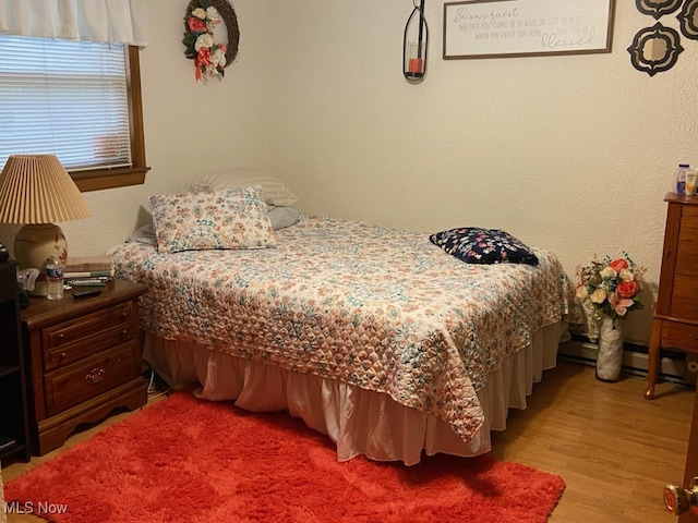 bedroom featuring light hardwood / wood-style floors and baseboard heating