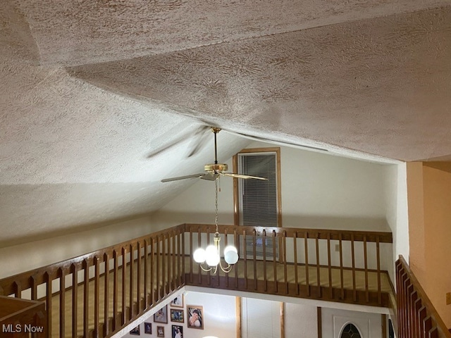 interior space with a notable chandelier, lofted ceiling, and a textured ceiling