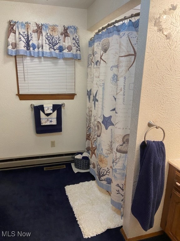 bathroom featuring vanity, curtained shower, and a baseboard heating unit