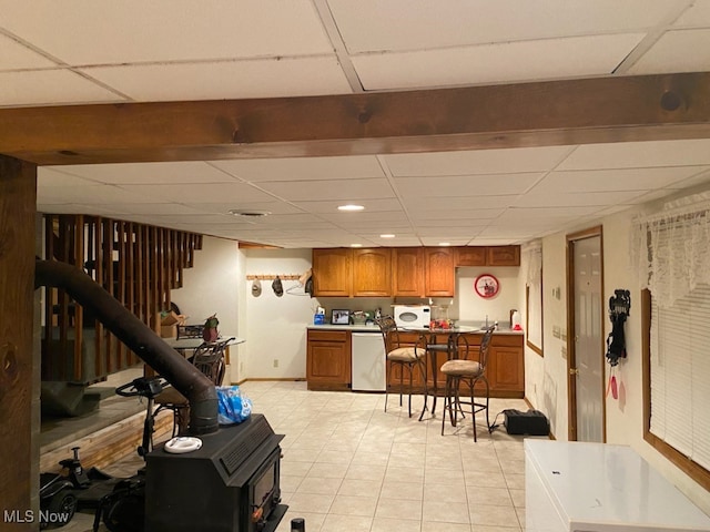 kitchen with a drop ceiling, light tile patterned floors, and stainless steel dishwasher