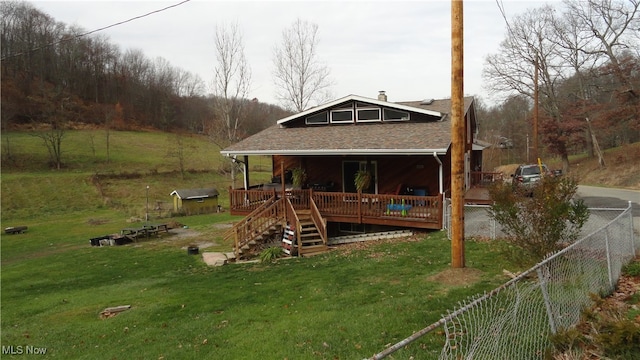 back of house featuring a lawn and a wooden deck