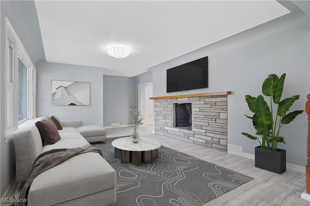 living room featuring a fireplace and light wood-type flooring