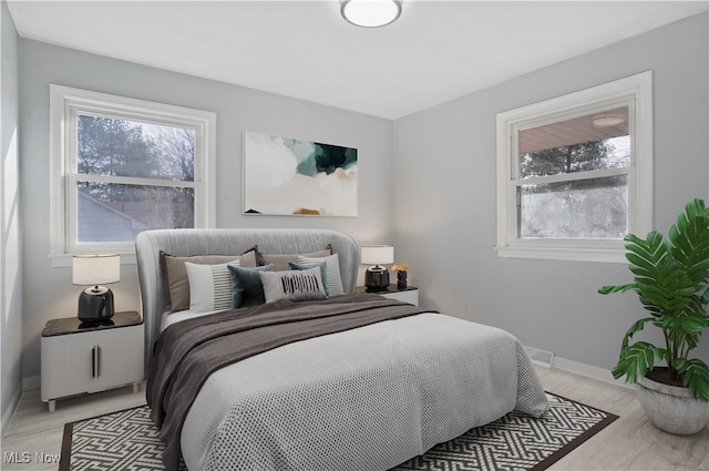 bedroom featuring multiple windows and light hardwood / wood-style floors