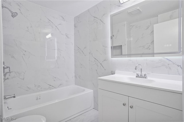 bathroom featuring tasteful backsplash, tile walls, vanity, and tiled shower / bath combo