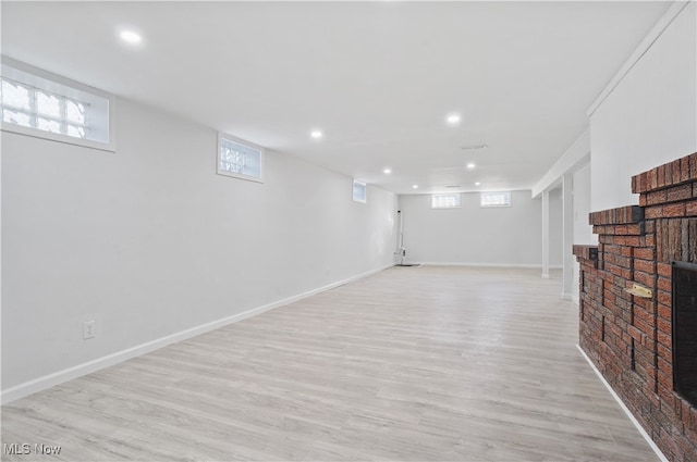 basement featuring plenty of natural light and light hardwood / wood-style floors