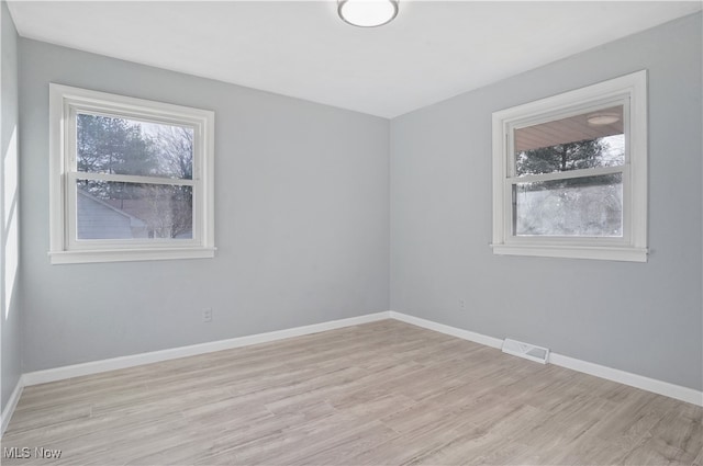 empty room featuring light hardwood / wood-style flooring and a wealth of natural light