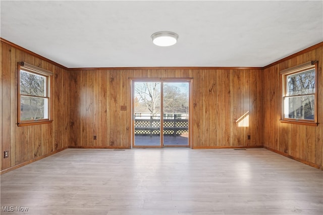 unfurnished room with a wealth of natural light and wood walls