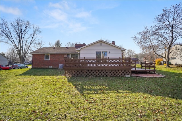 rear view of house featuring a deck and a yard