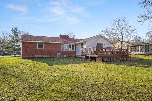 rear view of property with a sunroom, cooling unit, a yard, and a wooden deck