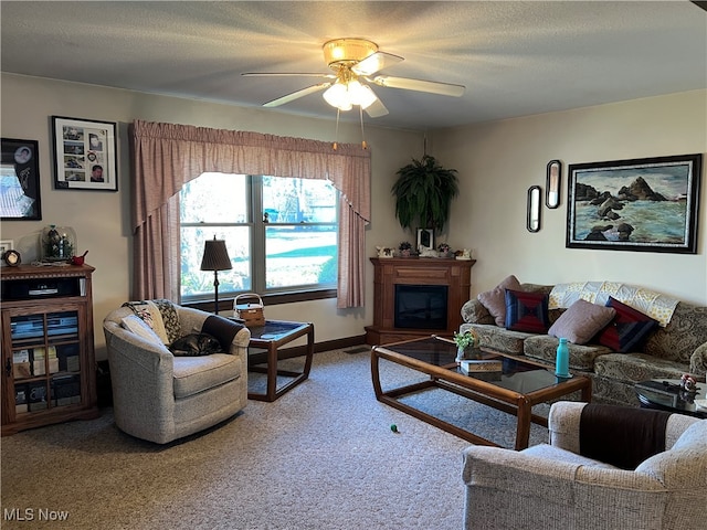 living room featuring carpet flooring, ceiling fan, and a textured ceiling