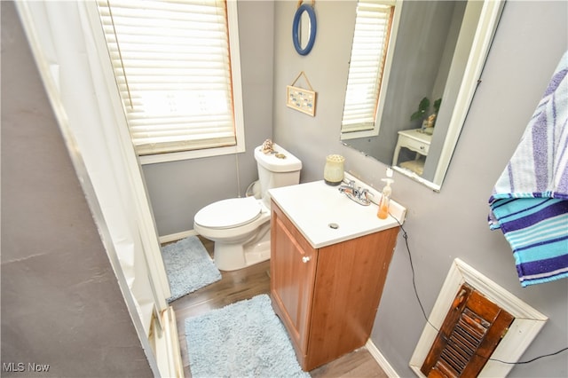 bathroom with hardwood / wood-style floors, vanity, and toilet