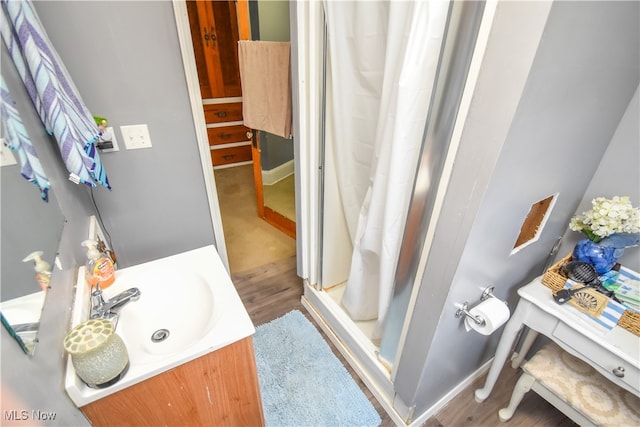 bathroom with a shower with curtain, hardwood / wood-style floors, and vanity