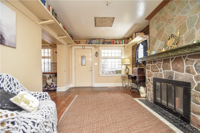 entrance foyer with a stone fireplace and hardwood / wood-style flooring