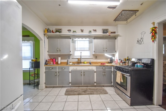 kitchen featuring gray cabinetry, stainless steel range with gas cooktop, and ornamental molding