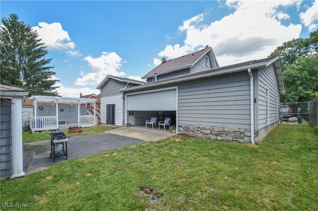 rear view of property with a garage and a yard