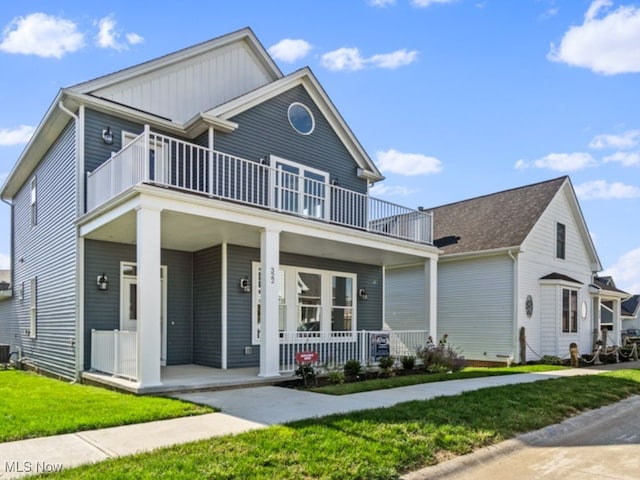 view of front facade with cooling unit, a balcony, a front lawn, and a porch