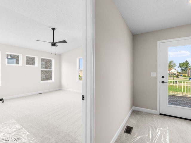 doorway featuring light carpet, ceiling fan, and lofted ceiling